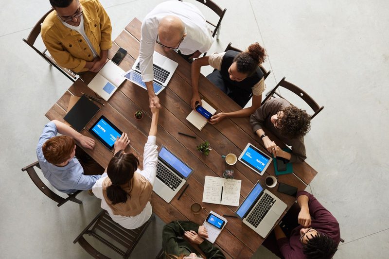 Promotional sales team reviewing campaign results together around a laptop