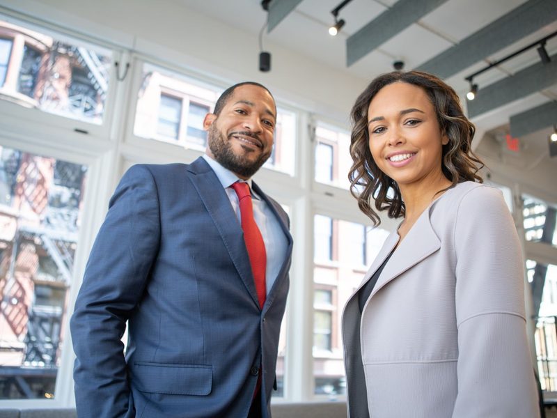 Two brand representatives in business attire standing inside a retail store
